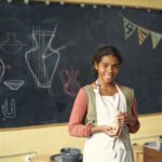 happy cute schoolgirl with clay pot standing by bl 2021 12 09 05 54 01 utc